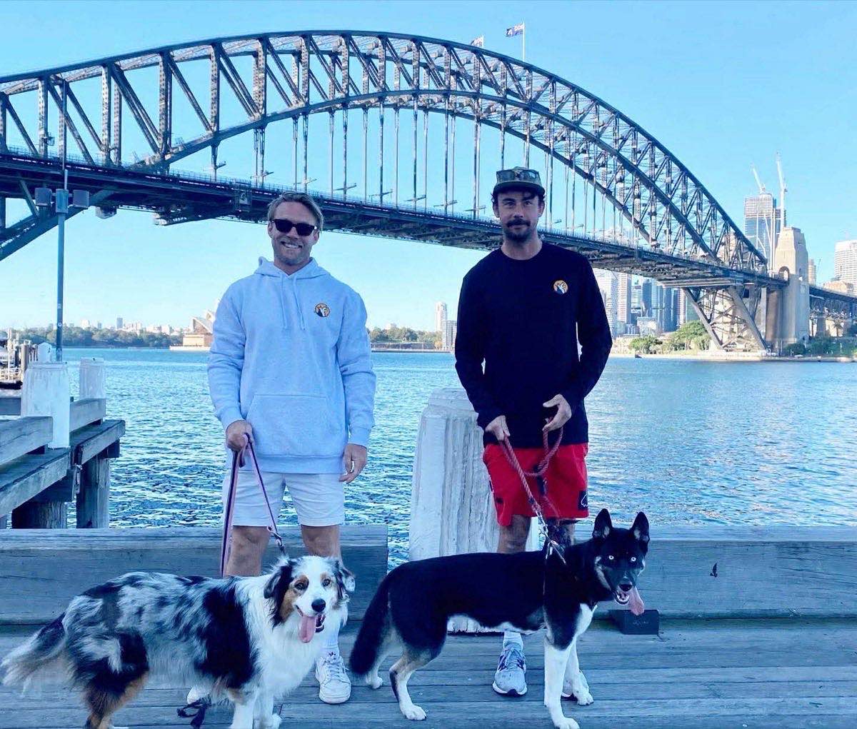 Coby Wilson and Billy Kennedy, founders of Bark Construction, at Sydney Harbour Bridge with their dogs