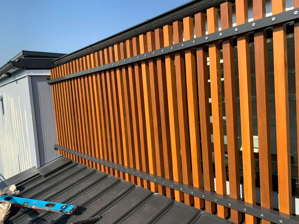 Vertical hardwood slat privacy screen on first-floor balcony