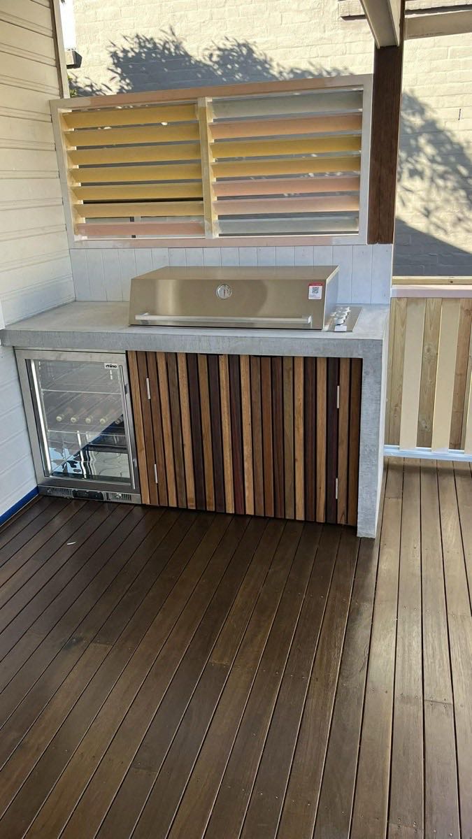 Outdoor kitchen with bar fridge and timber cladding