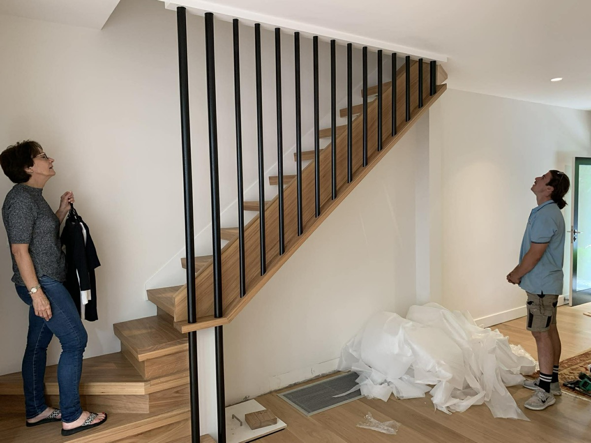 Internal timber staircase with black metal balustrade